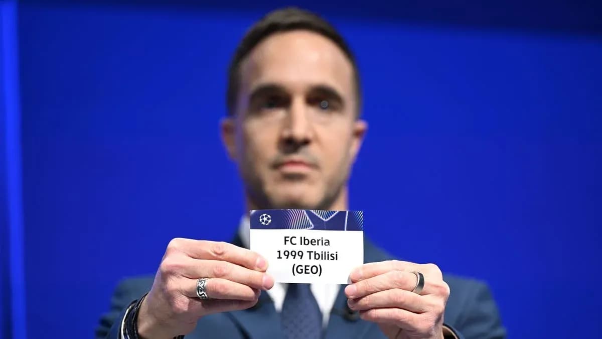 Человек держит карточку FC Iberia 1999 Tbilisi