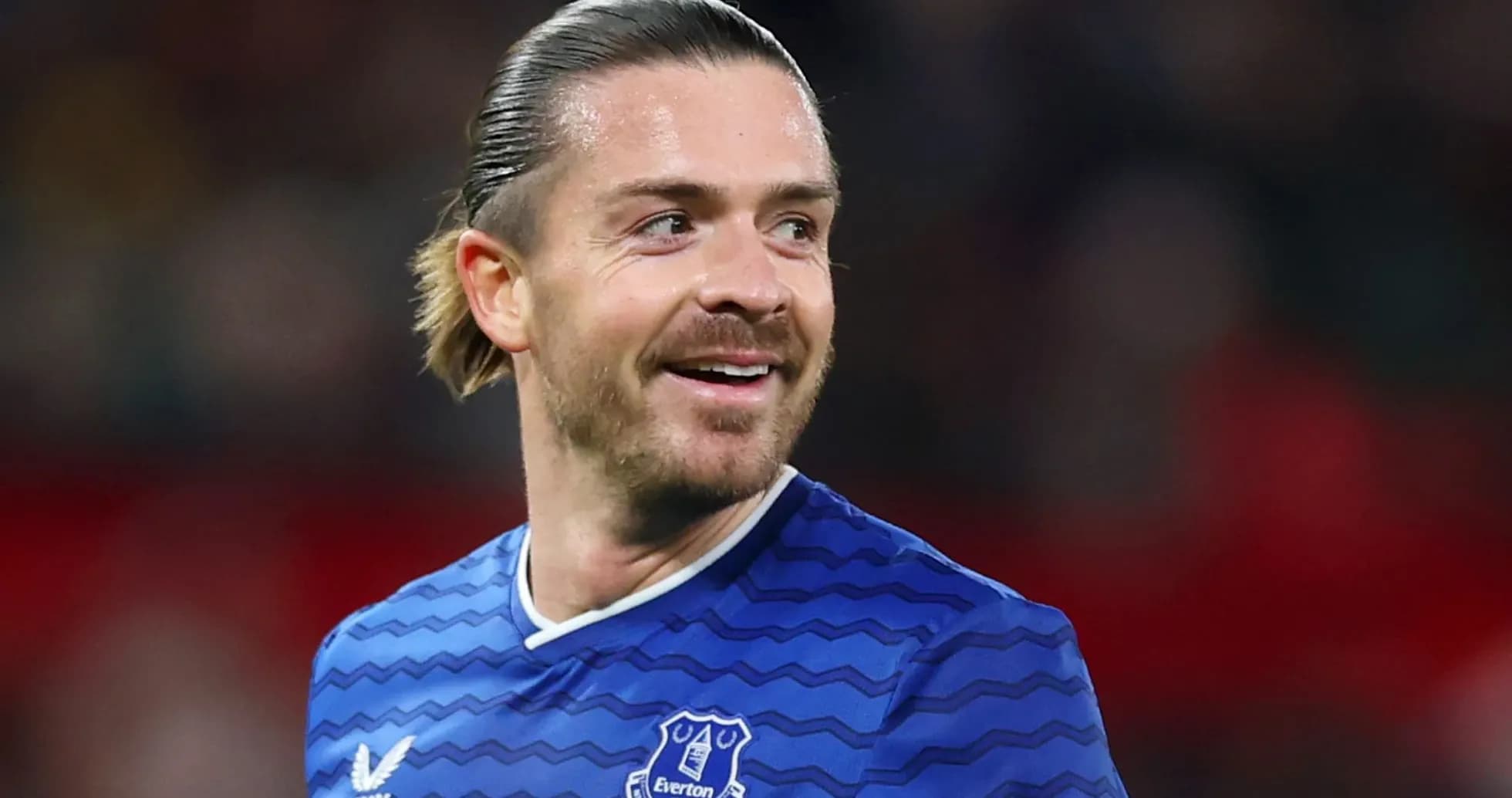 Игрок в синей форме Everton улыбается на поле