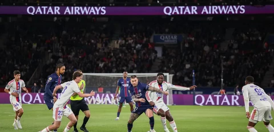 Игроки PSG и Lyon борются за мяч на поле