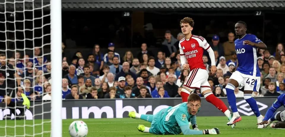 Игрок Arsenal забивает гол, вратарь на земле