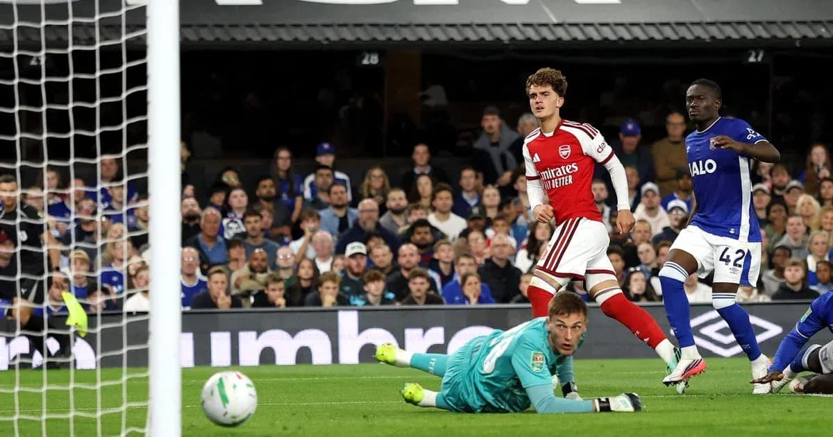 Игрок Arsenal забивает гол, вратарь на земле