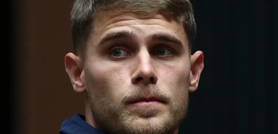 Игрок в спортивной одежде смотрит в сторону