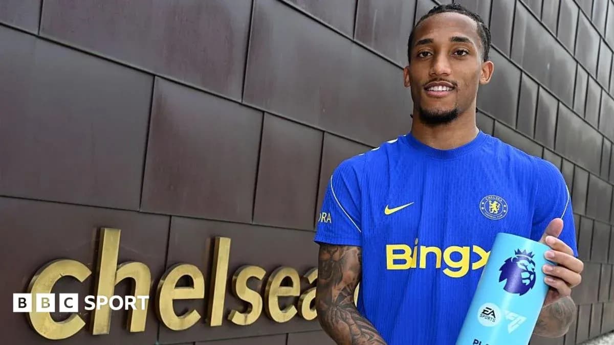 Игрок в синей форме Chelsea держит награду