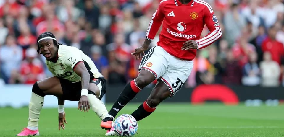 Игрок Manchester United ведет мяч, соперник падает