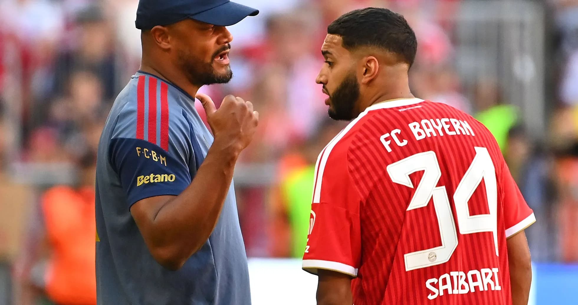 Тренер обсуждает с игроком FC Bayern на поле