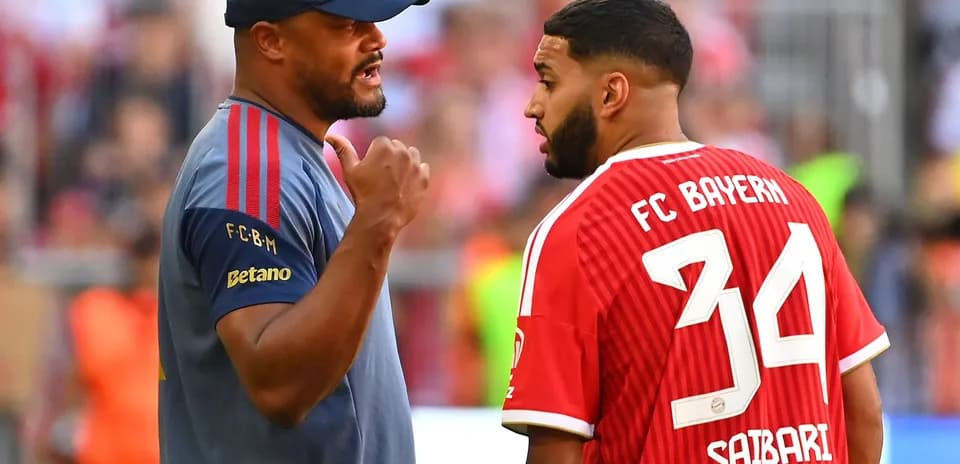 Тренер обсуждает с игроком FC Bayern на поле