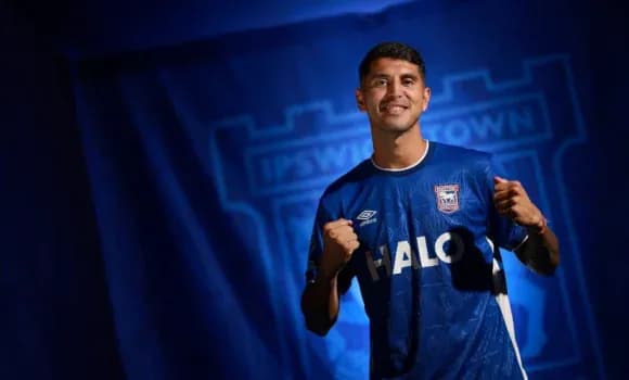 Игрок в футболке Ipswich Town позирует с кулаками