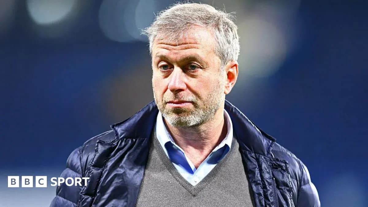 Человек в верхней одежде на фоне стадиона
