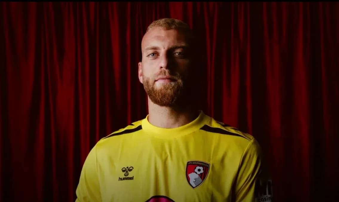 Игрок в желтой форме AFC Bournemouth на фоне занавеса