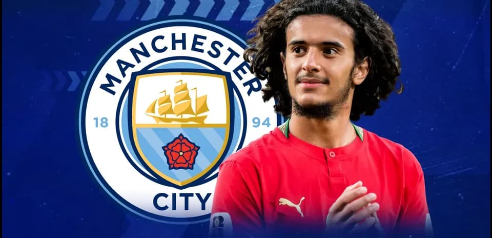 Игрок в красной форме на фоне логотипа Manchester City