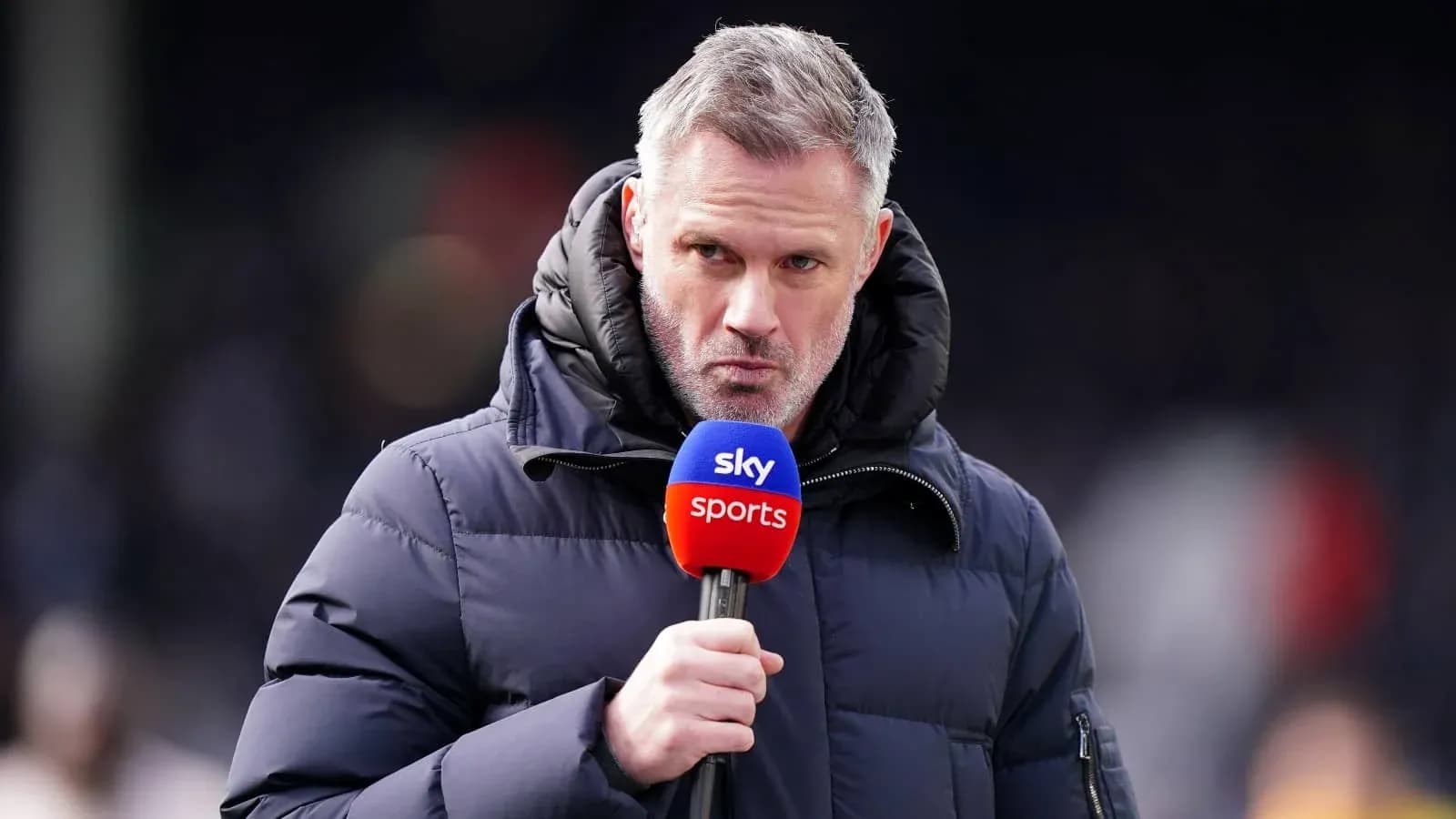 Комментатор с микрофоном Sky Sports на стадионе
