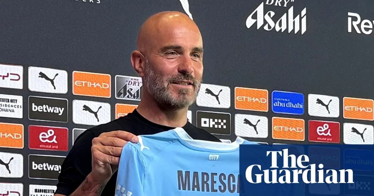 Тренер показывает футболку клуба Manchester City