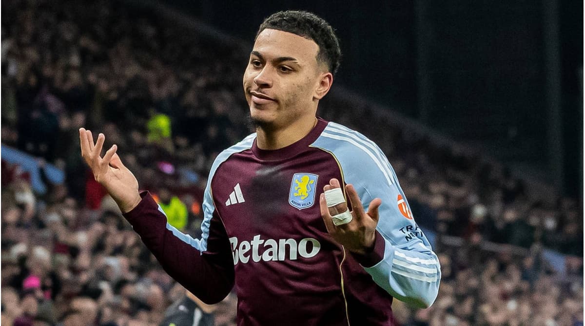 Игрок Aston Villa с поднятыми руками на поле
