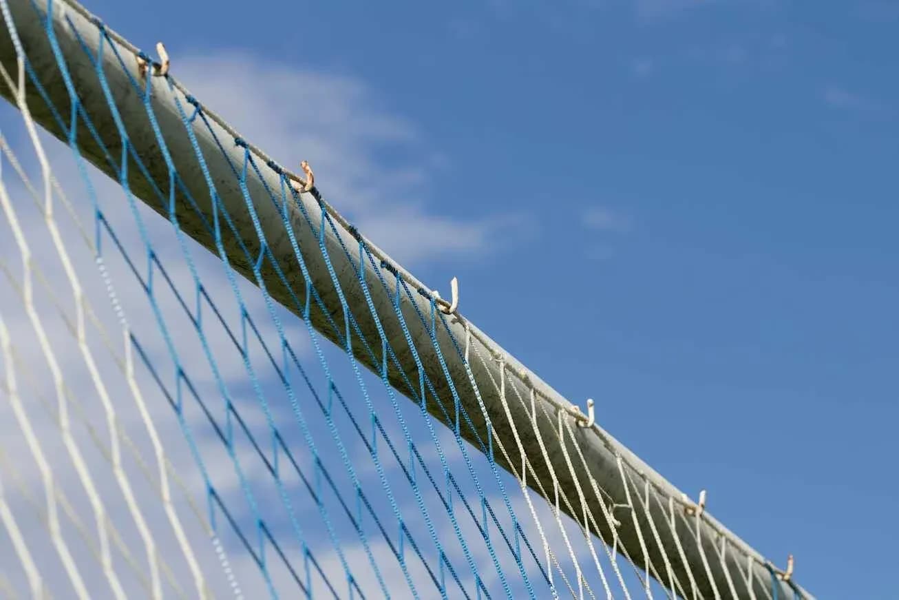 Close-up of a sports goal net against blue sky