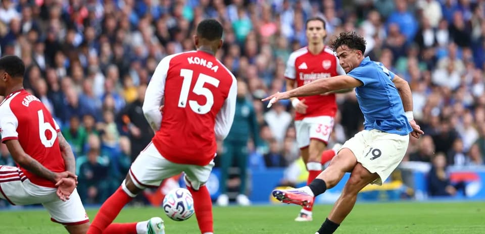 Игроки Arsenal и соперник в момент удара по мячу