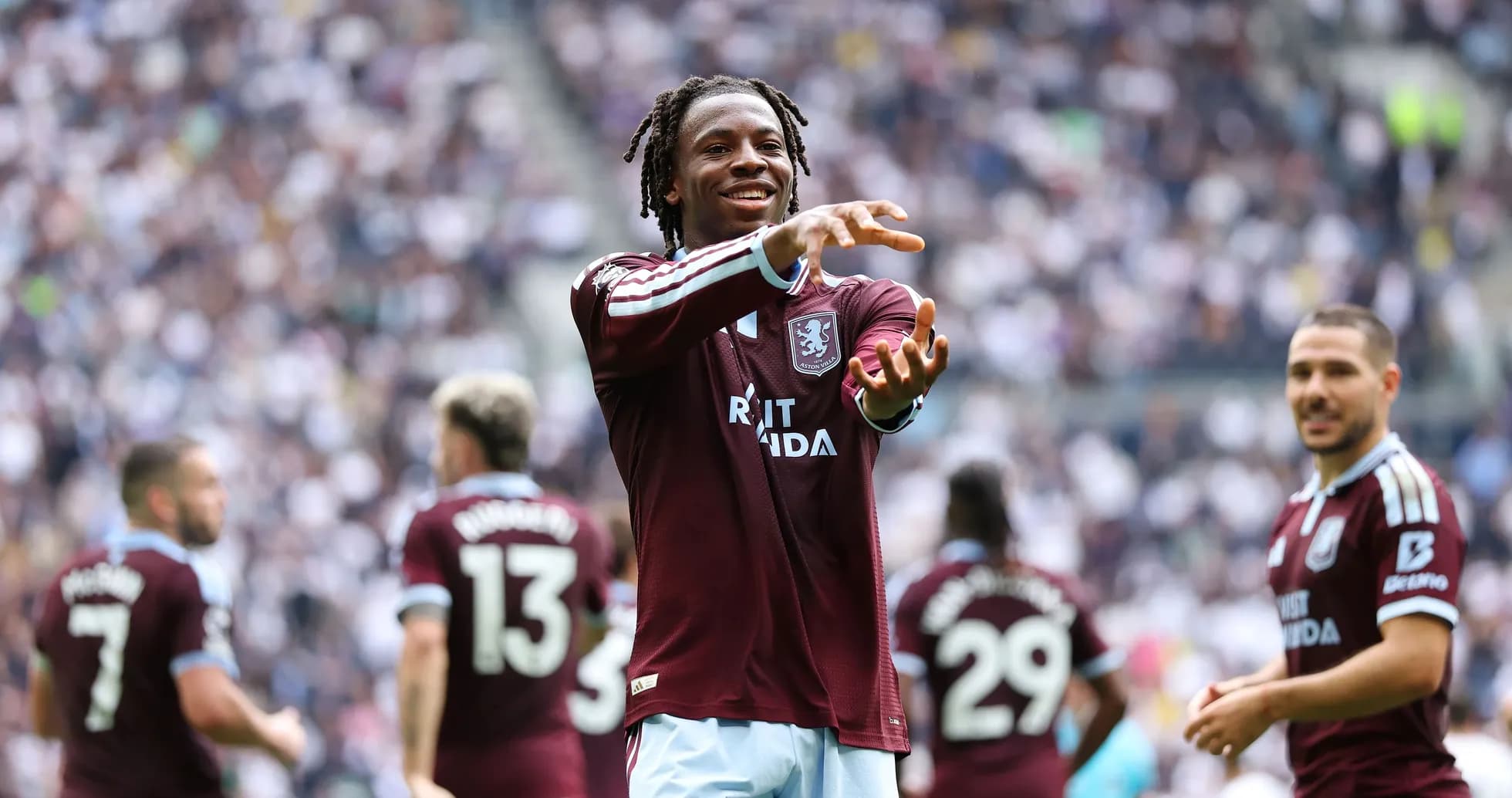 Игрок Aston Villa приветствует болельщиков на стадионе