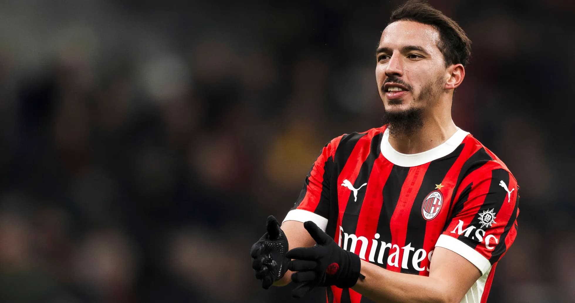 Игрок AC Milan в черно-красной форме на поле