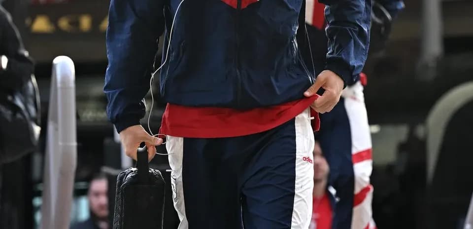 Игрок в спортивной одежде с сумкой на выходе