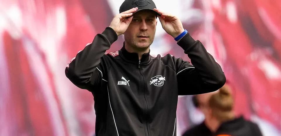 Тренер adjusts his cap during the match