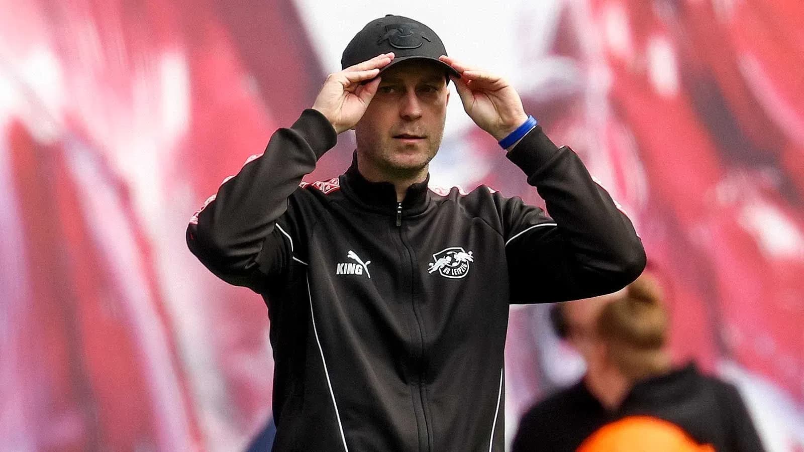 Тренер adjusts his cap during the match