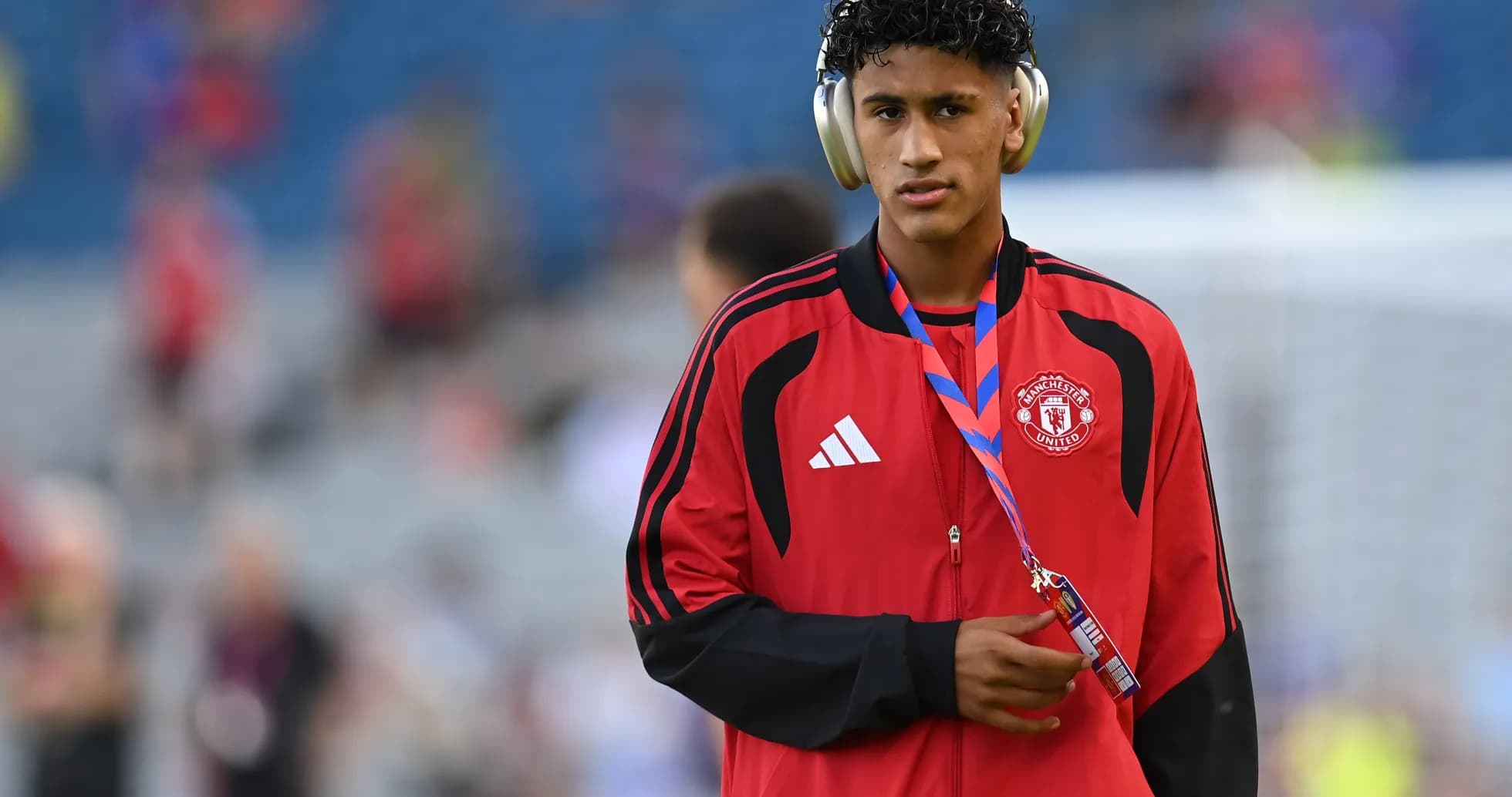 Игрок Manchester United в красной куртке с наушниками