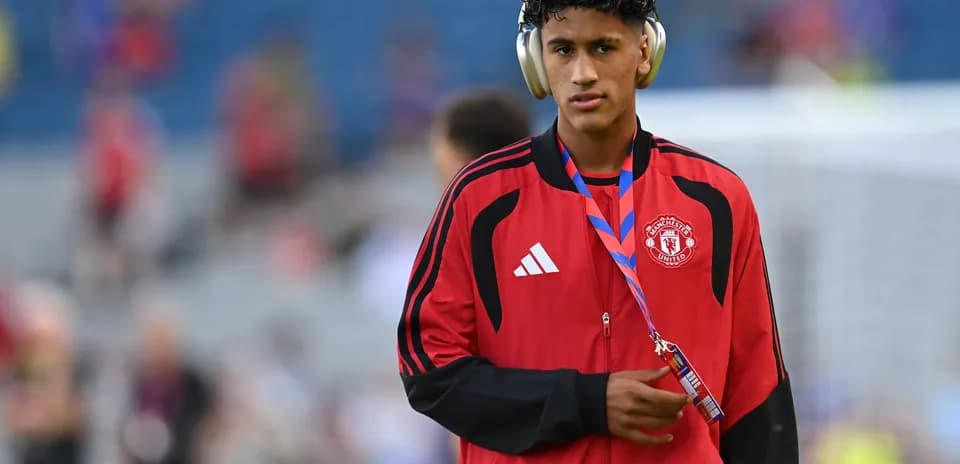 Игрок Manchester United в красной куртке с наушниками