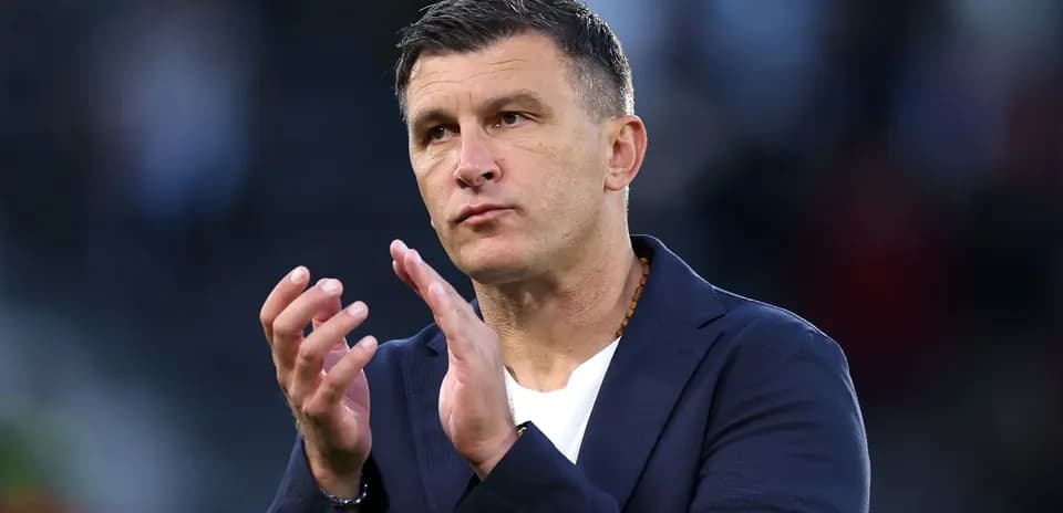 Тренер аплодирует на поле во время матча
