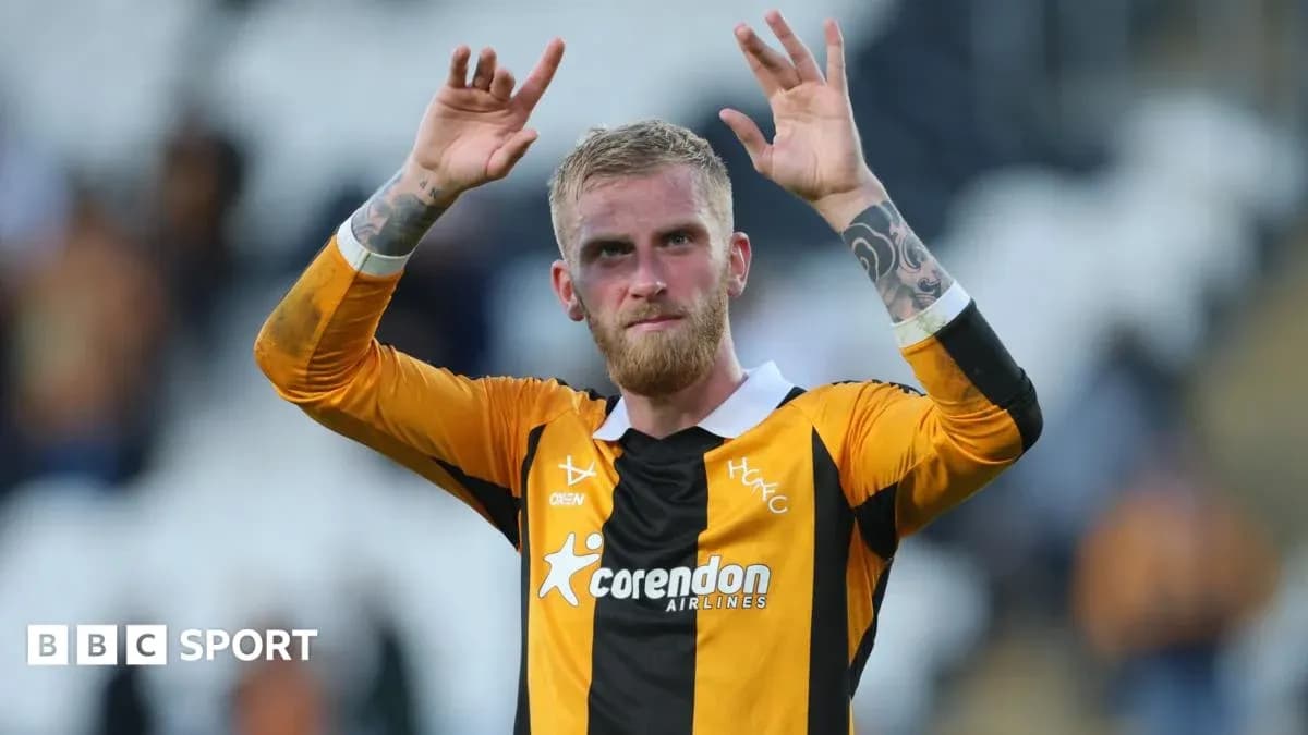 Игрок команды HFC с поднятыми руками на стадионе