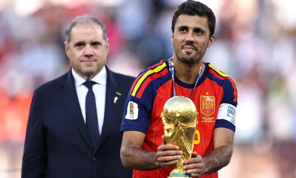 Игрок держит Кубок мира на пьедестале