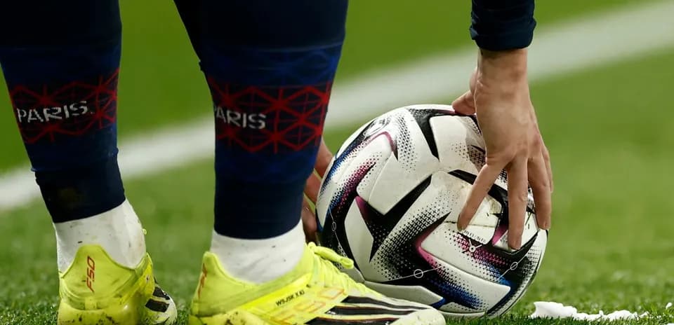 Игрок ставит мяч на поле перед ударом