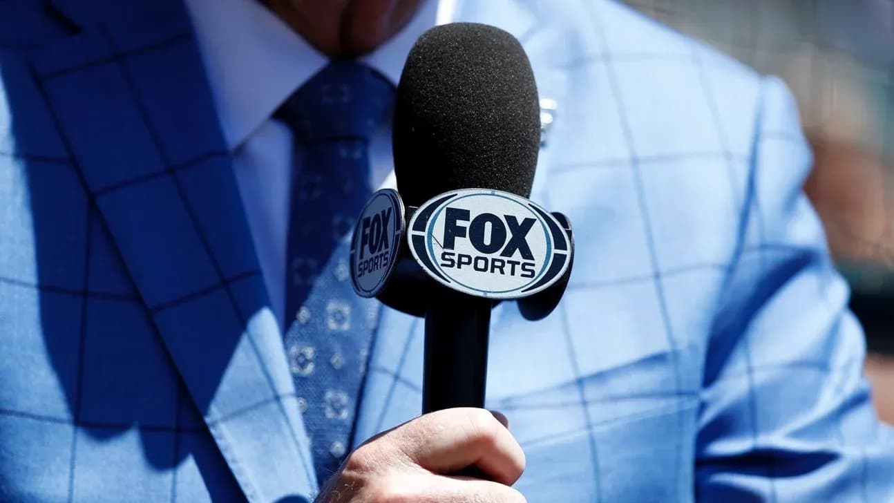 Микрофон FOX Sports в руке человека в костюме