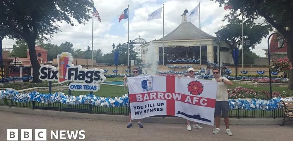 Два человека с флагом Barrow AFC у Six Flags