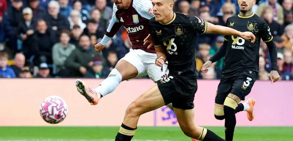 Футболист Aston Villa бьет по мячу