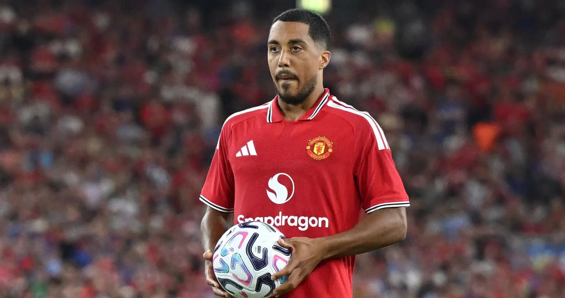 Игрок Manchester United держит мяч на поле Игрок Manchester United держит мяч на поле