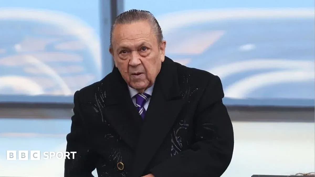 Человек в черном пальто на трибуне стадиона Человек в черном пальто на трибуне стадиона