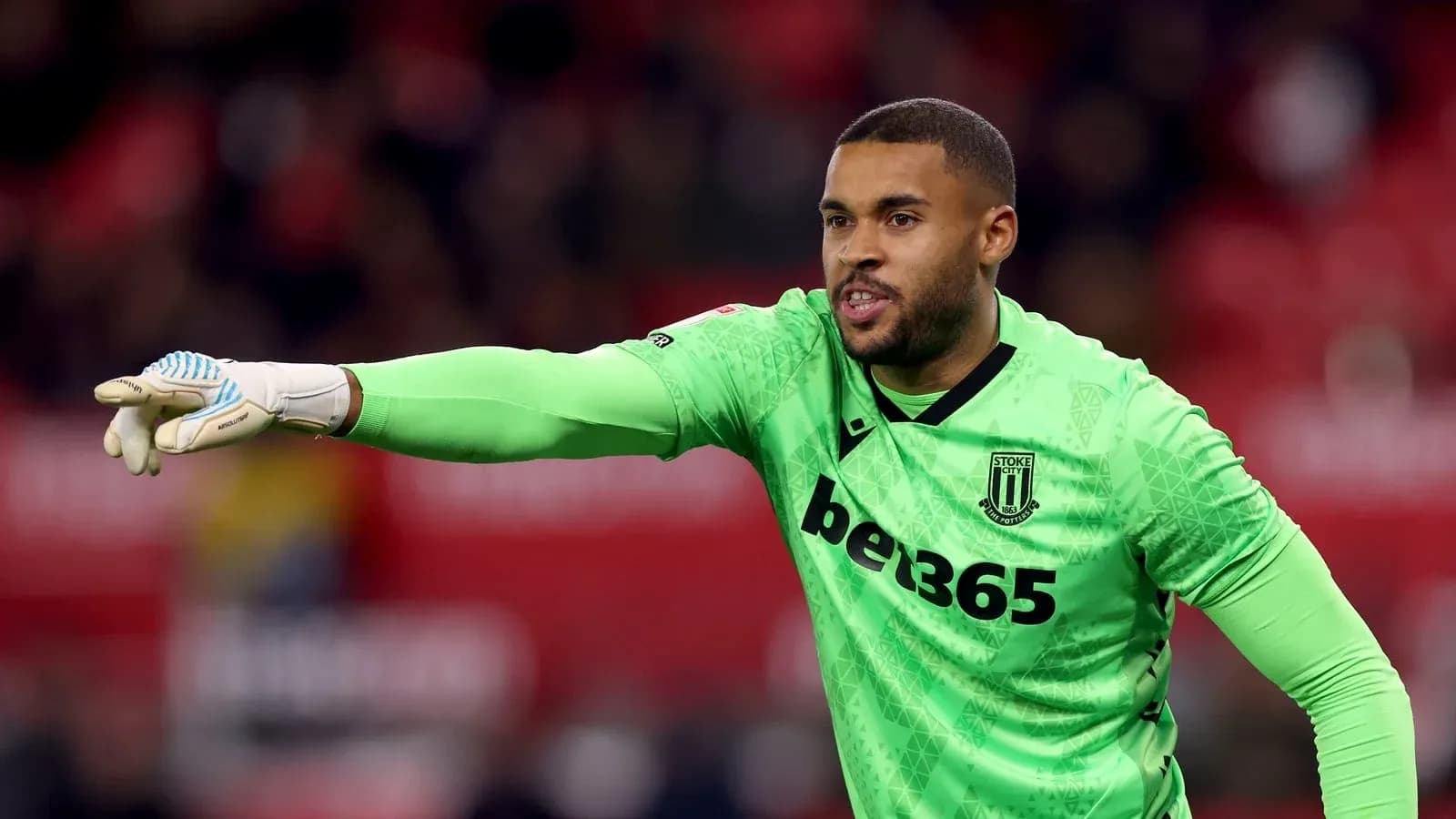 Вратарь Stoke City подает указания команде на поле Вратарь Stoke City подает указания команде на поле