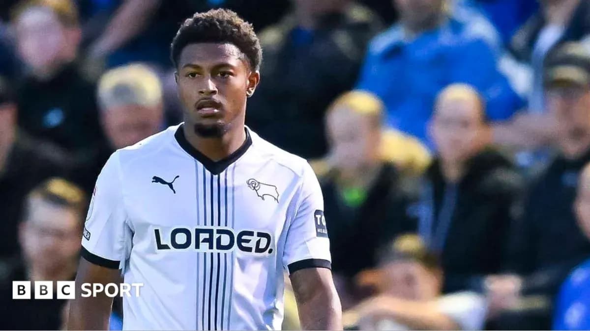 Игрок в белой форме команды Derby County на поле Игрок в белой форме команды Derby County на поле