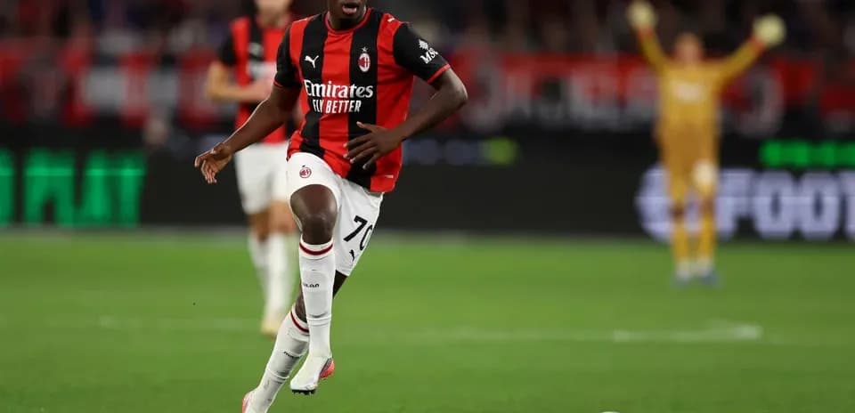 Игрок AC Milan бежит с мячом по полю Игрок AC Milan бежит с мячом по полю